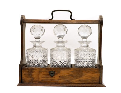 Lot 109 - An early 20th century oak triple tantalus