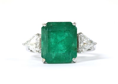 Lot 1190 - A white gold three stone emerald and diamond ring
