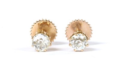 Lot 1011 - A pair of gold single stone diamond stud earrings