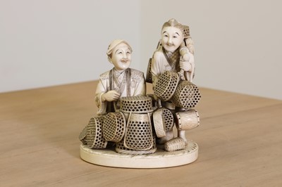 Lot 163 - A Japanese sectional carved ivory group of two basket sellers