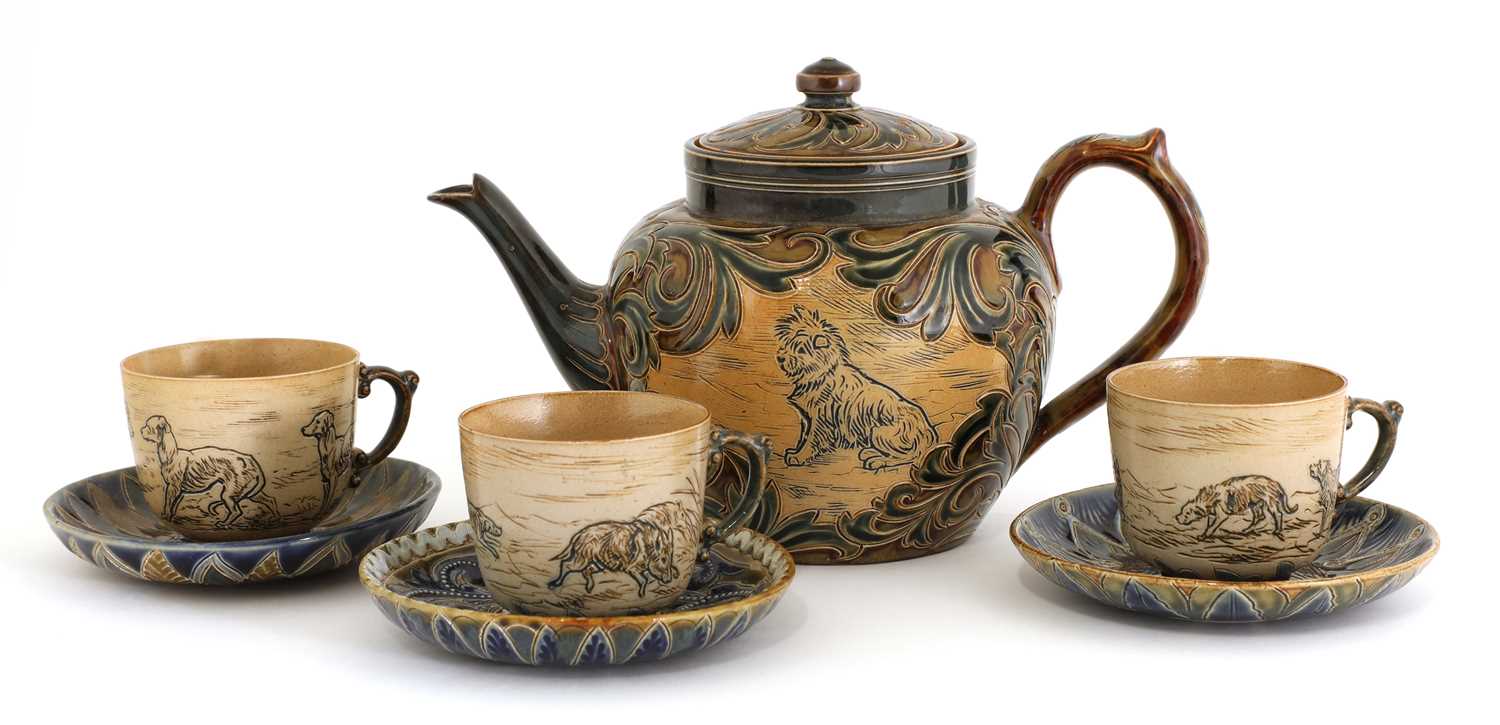 Lot 22 - A Doulton Lambeth teapot and three matched cups and saucers