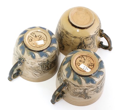 Lot 22 - A Doulton Lambeth teapot and three matched cups and saucers