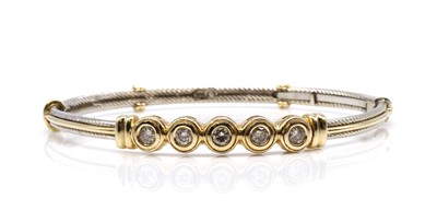 Lot 459 - An American two colour gold five stone diamond set hinged bangle, c.2005