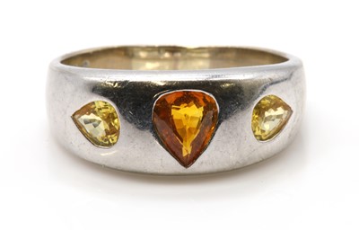 Lot 277 - A white gold three stone orange sapphire and yellow sapphire ring, by Astral Gemstone Talismans