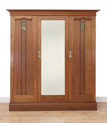 Lot 65 - An Arts and Crafts oak triple door wardrobe