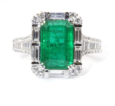 Lot 468 - A white gold emerald and diamond cluster ring