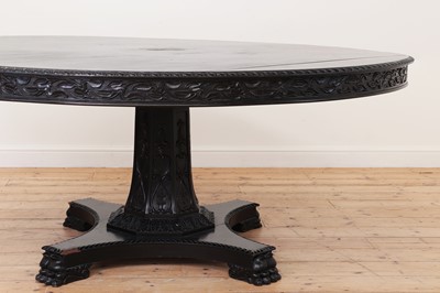 Lot 596 - An ebonised teak dining table