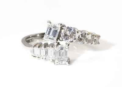 Lot 370 - An 18ct white gold two stone emerald cut diamond crossover ring