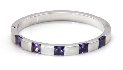 Lot 432 - A sapphire set hinged bangle