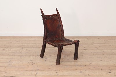 Lot 77 - A tribal hardwood and hide low chair