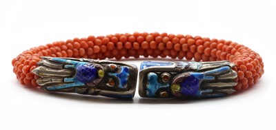 Lot 86 - A Chinese silver enamel and coral bead bangle