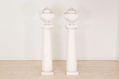 Lot 103 - A pair of plaster urns on pedestals