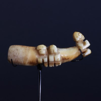 Lot 74 - A boar's tusk/tooth ear pendant 'Ha'akai' with three 'Tiki figures'