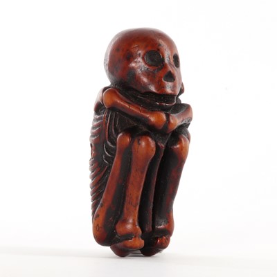 Lot 118 - A Japanese carved boxwood netsuke depicting a skeleton