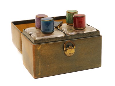 Lot 248 - A cased set guilloche enamel topped glass bottles