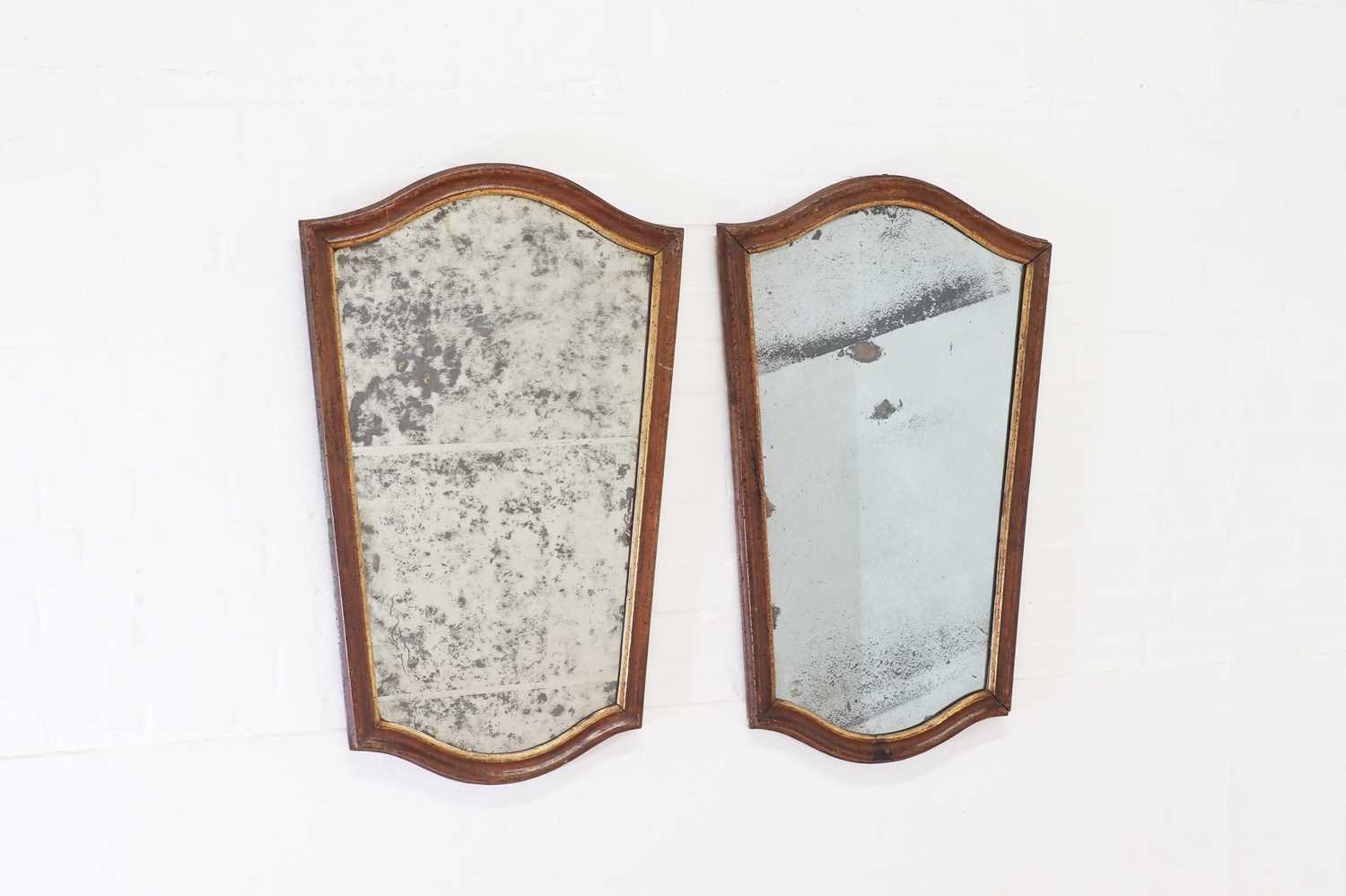 Lot 296 - A pair of walnut and parcel-gilt mirrors