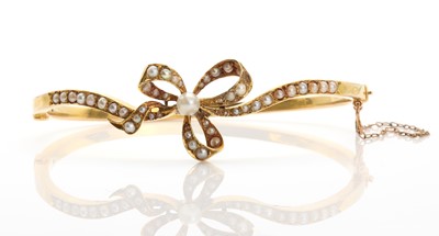 Lot 24 - An Edwardian split pearl set hinged bangle, c.1905