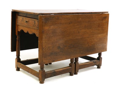 Lot 490 - An 18th century oak drop-leaf dining table