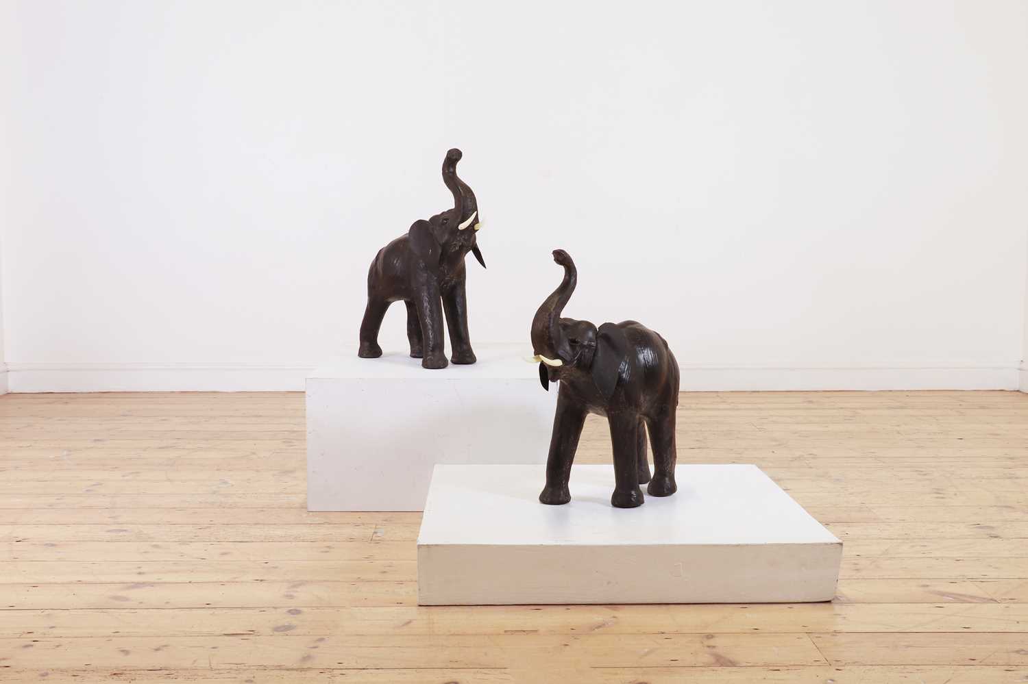 Lot 139 - A near pair of small leather elephants