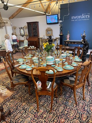 Lot 297 - A Regency-style walnut extending dining table in the manner of Johnstone, Jupe & Co.