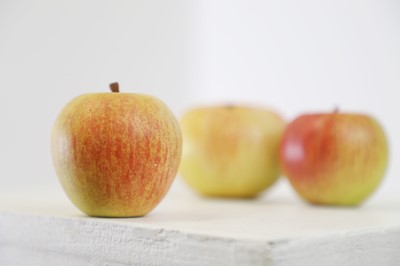 Lot 450 - Three painted wood apples by Howard Rice