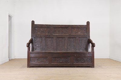 Lot 42 - A carved oak settle