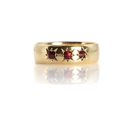 Lot 1120 - A large gold band ring set with garnets