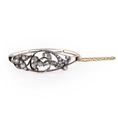 Lot 18 - A scroll design diamond hinged bangle, c.1890-1900