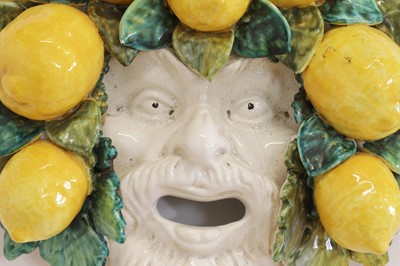 Lot 146 - A pair of glazed pottery wall-hanging masks
