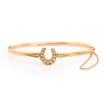 Lot 25 - An early 20th century gold split pearl horseshoe bangle