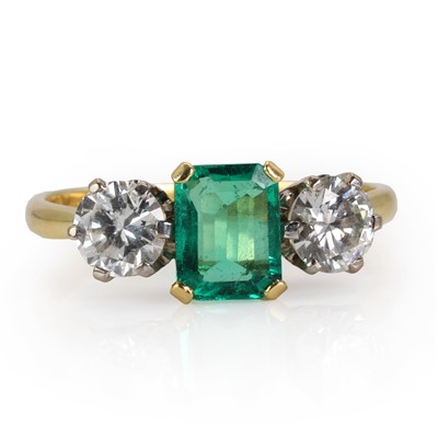 Lot 180 - An 18ct gold Colombian emerald and diamond three stone ring