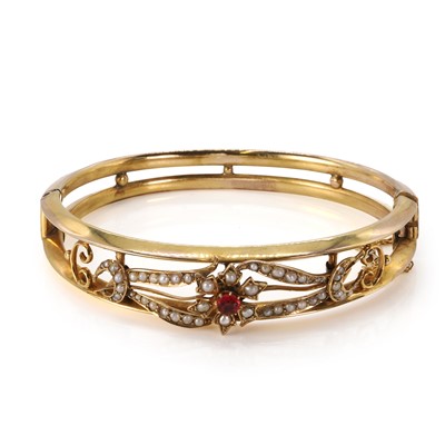 Lot 28 - An Edwardian gold split pearl hinged bangle
