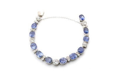 Lot 56 - A Ceylon sapphire and diamond rivière bracelet, c.1920