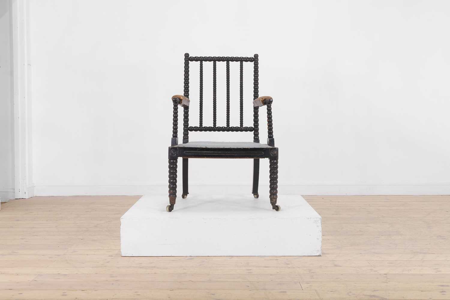 Lot 158 - An ebonised bobbin-framed nursing chair