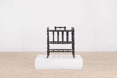 Lot 23 - An ebonised wooden magazine rack
