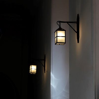 Lot 367 - A set of twenty-four black-painted iron wall lanterns