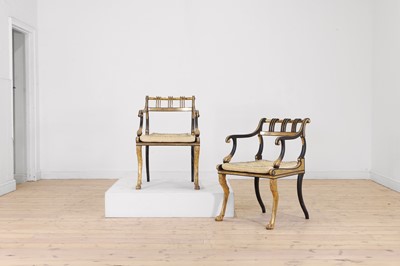 Lot 180 - A pair of Regency-style ebonised and parcel-gilt wooden elbow chairs