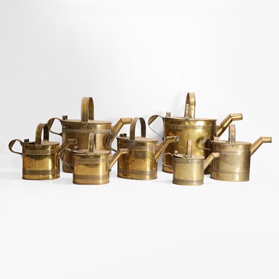 Lot 494 - A graduated set of Regency brass watering cans