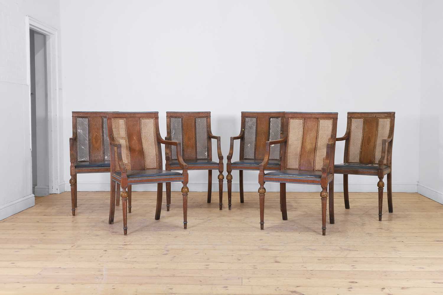 Lot 52 - A set of six oak and cane elbow chairs