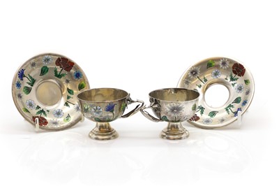 Lot 37 - Two sets of silver and enamelled teacups and saucers