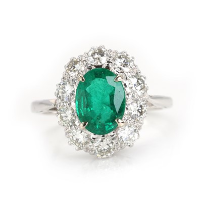Lot 258 - A white gold emerald and diamond cluster ring