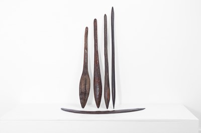 Lot 382 - Four carved wood throwing clubs and a boomerang
