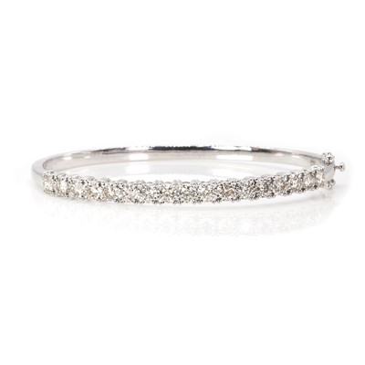 Lot 110 - A 9ct white gold diamond hinged bangle