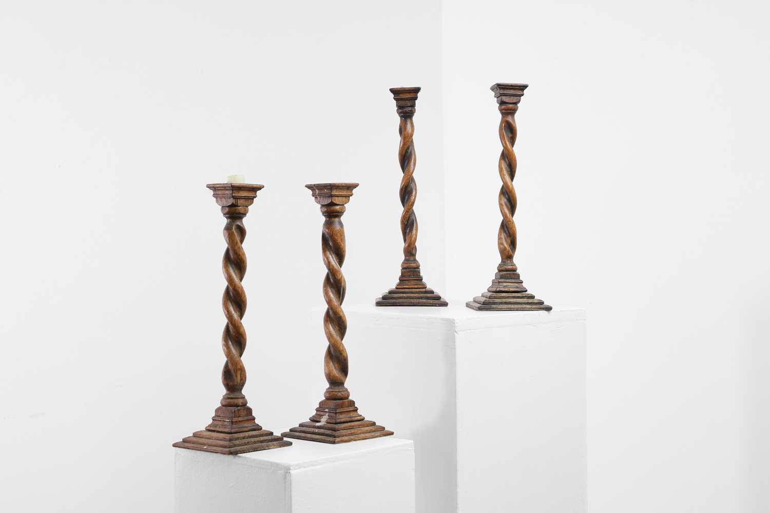 Lot 36 - A set of four turned oak candlesticks