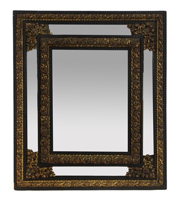 Lot 554 - A Northern European brass and ebonised cushion mirror