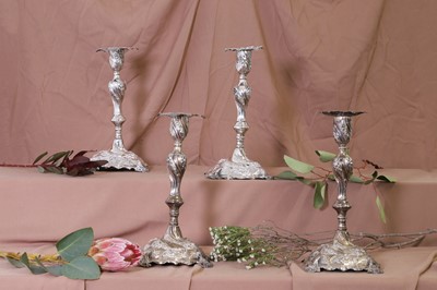Lot 304 - A set of four rococo-style silver candlesticks