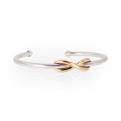 Lot 169 - A silver and gold infinity bangle, by Tiffany & Co.