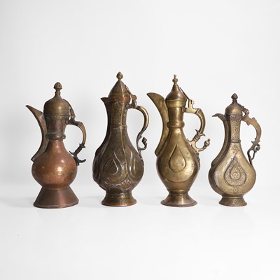 Lot 24 - A collection of four copper and brass ewers