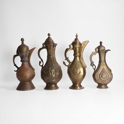 Lot 24 - A collection of four copper and brass ewers