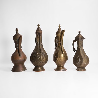 Lot 24 - A collection of four copper and brass ewers